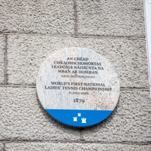 Photogrraph of a Dublin City Council commemorative plaque. The text on the plaque says 'An Chéad Chraobhchomórtas Leadóige Náisiúnta na mBan ar domhan arna imríodh anseo World's First National Ladies’ Tennis Championship played here 1879'.
