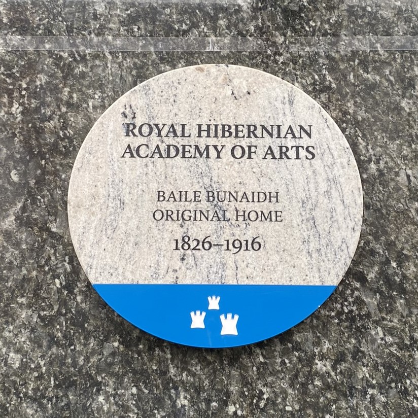Photogaph of plaque with black text on grey granite. The text says ROYAL HIBERNIAN ACADEMY OF ART baile bunaidh original home 1826-1916