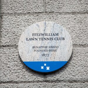 Photograph of a Dublin City Council commemorative plaque. The text on the plaque reads 'Fitzwilliam Lawn Tennis Club bunaithe anseo founded here 1877'.