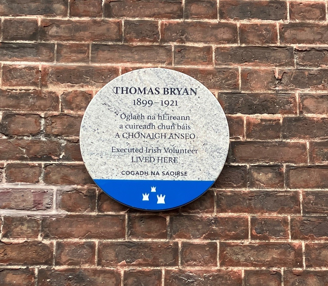 Photograph of a Dublin City Council commemorative plaque at 14 Henrietta Street, Dublin. The text on the plaque is in black on a marbled background and says in Irish and English 'Thomas Bryan, 1899-1921, Óglach na hÉireann, a cuireadh chun báis, A CHÓNAIGH ANSEO, Executed Irish Volunteer, Lived Here COGADH NA SAOIRSE '. Below the text is a blue panel with the three castles logo in white.